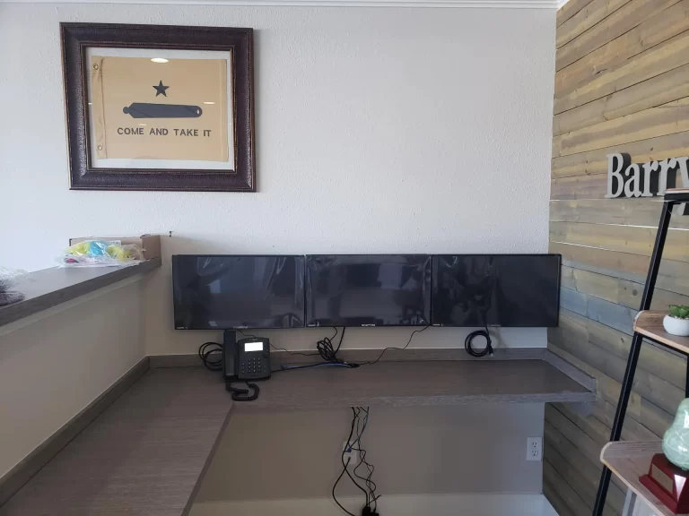 Triple-monitor workstation and business phone installed at Barry's Insurance