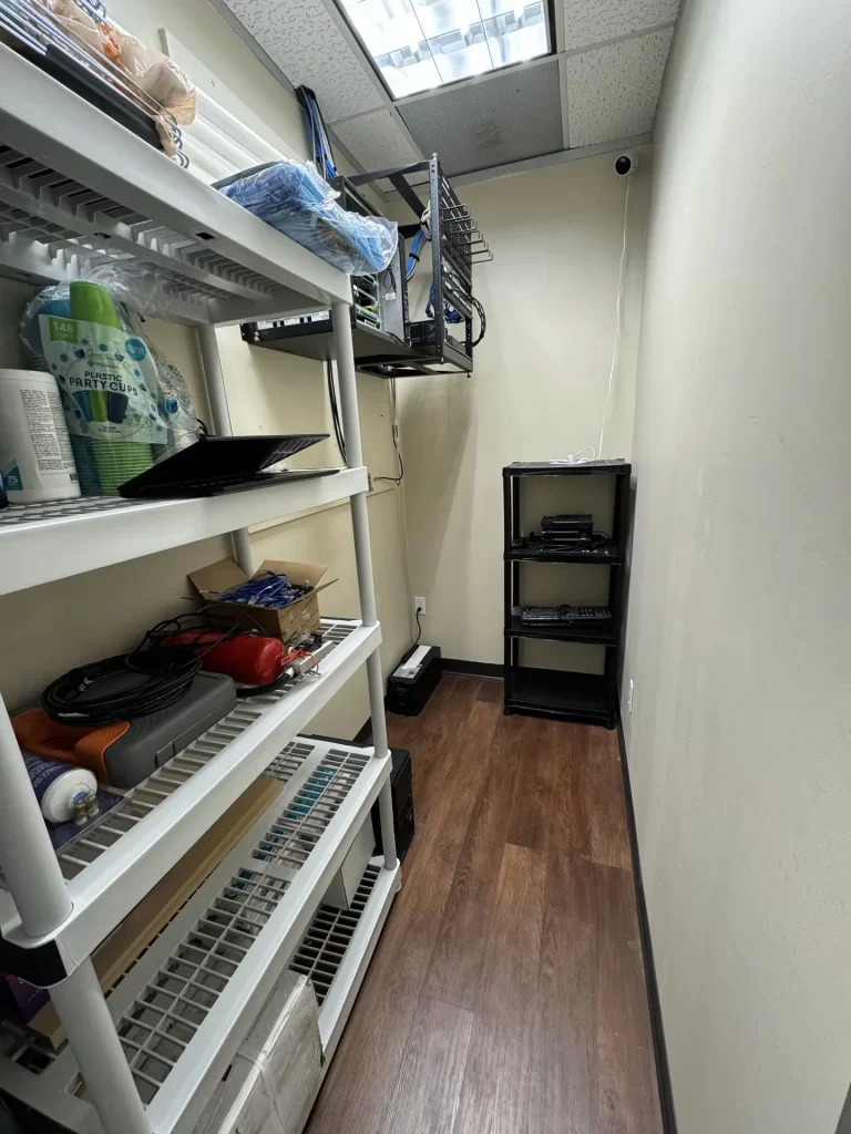 Network room after SpaceCenter Systems cleanup with wall-mounted rack at Windy Hill